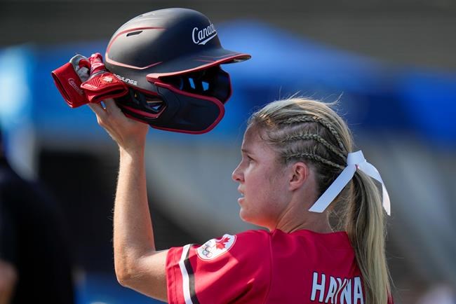 Canada's Victoria Hayward holds her helmet aloft during the softball game between Mexico and Canada at the 2020 Summer Olympics, Wednesday, July 21, 2021, in Fukushima , Japan. (AP Photo/Jae C. Hong)