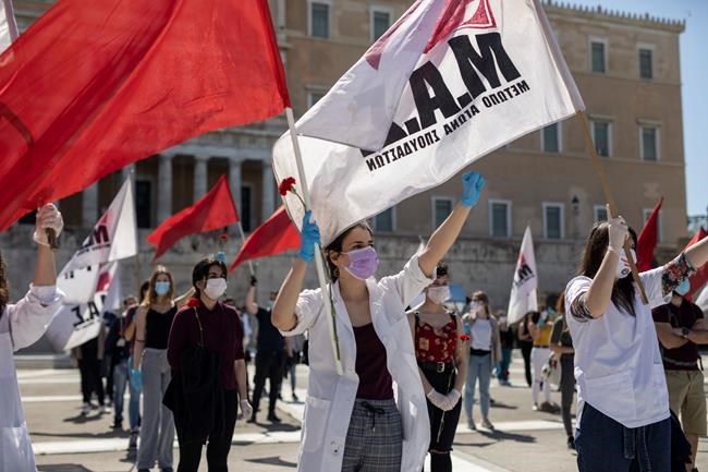 Protesters from the communist party-affiliated PAME union wearing masks to protect against coronavirus, march during a May Day rally outside the Greek Parliament, in Athens, on Friday, May 1, 2020. Hundreds of protesters gathered in central Athens and the northern Greek city of Thessaloniki to mark May Day, despite appeals from the government for May Day marches and commemorations to be postponed until next Saturday, when some lockdown measures will have been lifted. (AP Photo/Petros Giannakouris)