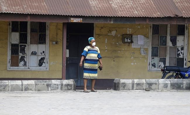 A woman wearing a face mask walks at the Yaba Mainland hospital where the first Nigerian victims of the COVID-19 virus are being treated in Lagos Nigeria Friday, Feb. 28, 2020. Nigeria's health authorities have reported the country's first case of a new coronavirus in Lagos, the first confirmed appearance of the disease in sub-Saharan Africa. (AP Photo/ Sunday Alamba)