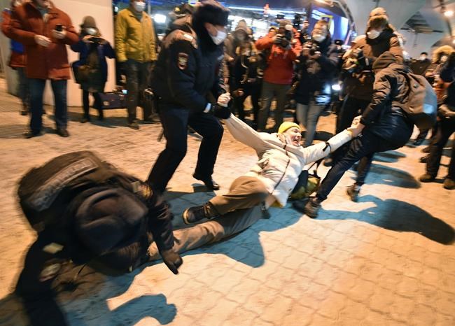 Police officers detain a man at Moscow's Vnukovo airport where Russian opposition leader Alexei Navalny is expected to arrive, outside Moscow, Russia, Sunday, Jan. 17, 2021. Leading Kremlin critic Alexei Navalny flew home to Russia on Sunday after recovering in Germany from his poisoning in August with a nerve agent. (AP Photo/Dmitry Serebryakov)