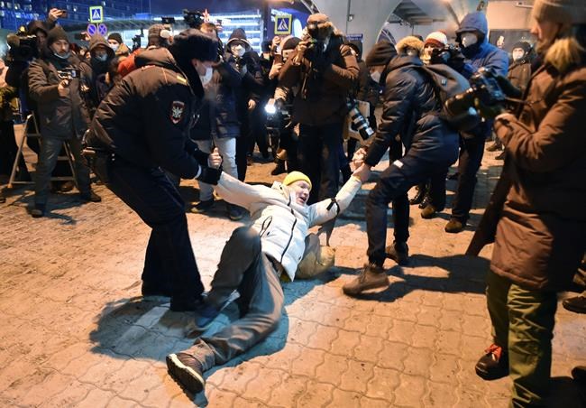 Police officers detain a man at Moscow's Vnukovo airport where Russian opposition leader Alexei Navalny is expected to arrive, outside Moscow, Russia, Sunday, Jan. 17, 2021. Leading Kremlin critic Alexei Navalny flew home to Russia on Sunday after recovering in Germany from his poisoning in August with a nerve agent. (AP Photo/Dmitry Serebryakov)