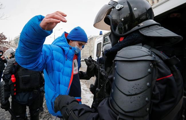 Police officers search a man during a protest against the jailing of opposition leader Alexei Navalny in Moscow, Russia, on Sunday, Jan. 31, 2021. Thousands of people took to the streets Sunday across Russia to demand the release of jailed opposition leader Alexei Navalny, keeping up the wave of nationwide protests that have rattled the Kremlin. Hundreds were detained by police. (AP Photo/Alexander Zemlianichenko)
