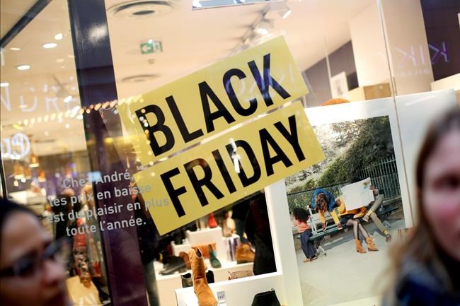 Women stand in front of a poster promoting the Black Friday in the business district of Paris, La Défense, in Paris, Friday, Nov. 29, 2019. People don't celebrate Thanksgiving in France, or Denmark, or the Czech Republic, but they do shop on Black Friday. The U.S. sales phenomenon has spread to retailers across the Atlantic in recent years. (AP Photo/Thibault Camus)