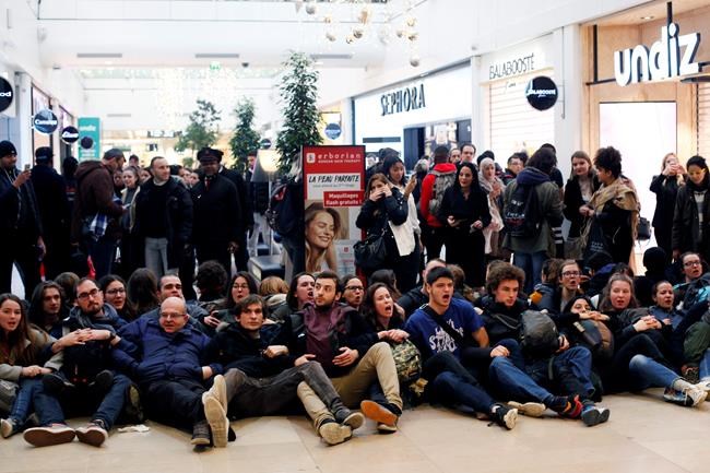 Activists block a shopping center, in the business district of Paris, La Défense, in Paris, Friday, Nov. 29, 2019. People don't celebrate Thanksgiving in France, or Denmark, or the Czech Republic, but they do shop on Black Friday. The U.S. sales phenomenon has spread to retailers across the Atlantic in recent years. (AP Photo/Thibault Camus)