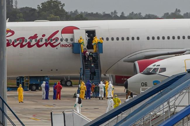 Indonesian people arrive from Wuhan, China, at Hang Nadim Airport in Batam, Indonesia Sunday, Feb. 2, 2020. Indonesians evacuated from Wuhan, the Chinese city at the center of a deadly virus outbreak, were transported to a quarantine zone on a remote island at the edge of the South China Sea, shortly after landed on Batam, an island near Singapore on Sunday morning. (AP Photo/Luth Panjalu)
