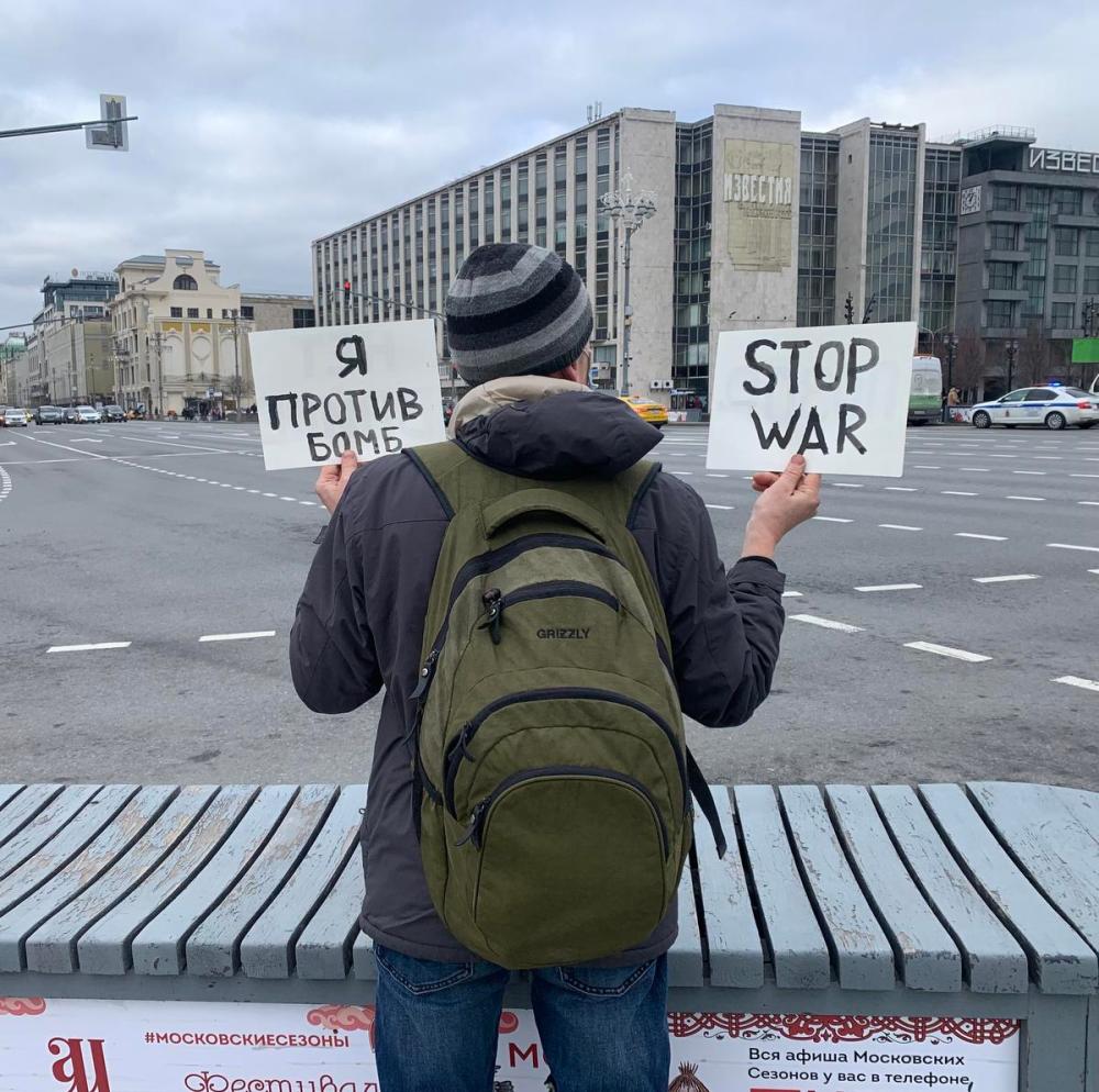 Allan Woods
In Moscow’s Pushkin Square on Thursday, Ilya Povyshev holds two signs, with the one in Russian saying “I am against bombs.”
