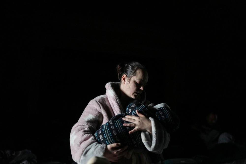 Evgeniy Maloletka - The Associated Press
A woman holds a baby in a bomb shelter in Mariupol, Ukraine on Tuesday.
