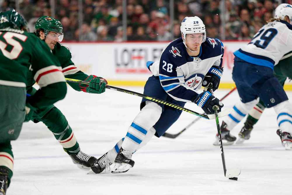 CP
Winnipeg Jets center Jack Roslovic (28) controls the puck in front of Minnesota Wild left wing Marcus Foligno (17) in the second period. (Andy Clayton-King/The Associated Press)