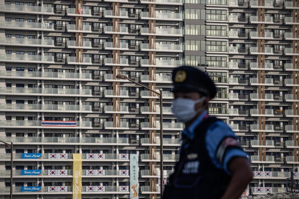 Carl Court - GETTY IMAGES
A police officer stands guard next to an accommodation building in the Tokyo Olympics athletes village on July 19, 2021 in Tokyo, Japan.
