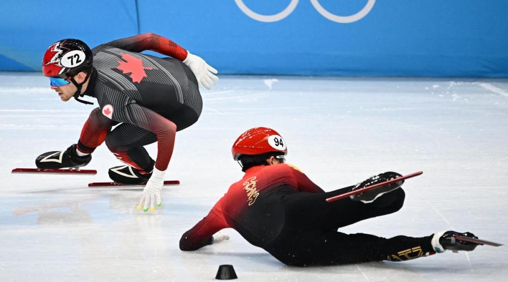 ANNE-CHRISTINE POUJOULAT - GETTY IMAGES
Canada’s Pascal Dion skates past fallen Chinese skater Li Wenlong in the short-track relay semifinals. Later, a review determined there was no illegal contact in the race, but both teams will advance to the final.