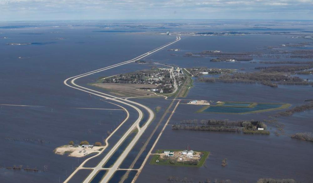 JOHN WOODS - THE CANADIAN PRESS
St Jean Baptiste, Man., which runs along highway 75, is protected against Red River flooding by a dike south of Winnipeg on May 15, 2022. The Manitoba town of Minnedosa has just declared a state of emergency because of flooding, Heather Scoffield writes.