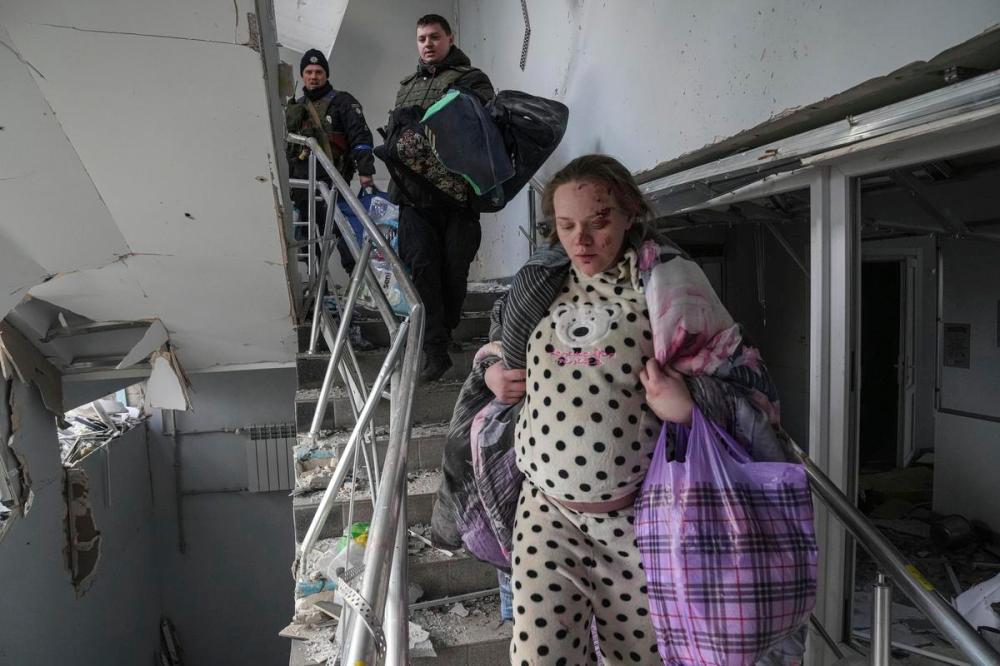 Evgeniy Maloletka - AP
An injured pregnant woman walks downstairs at a maternity hospital shelled by Russian forces in Mariupol, Ukraine on March 9, 2022.