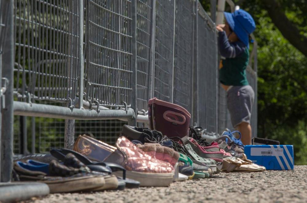 Rick Madonik - Toronto Star
A child peers over a fence outside Queen’s Park Sunday where children’s shoes have been placed in a makeshift memorial honouring the 215 children whose remains were found on the grounds of a former residential school in Kamloops, B.C.
