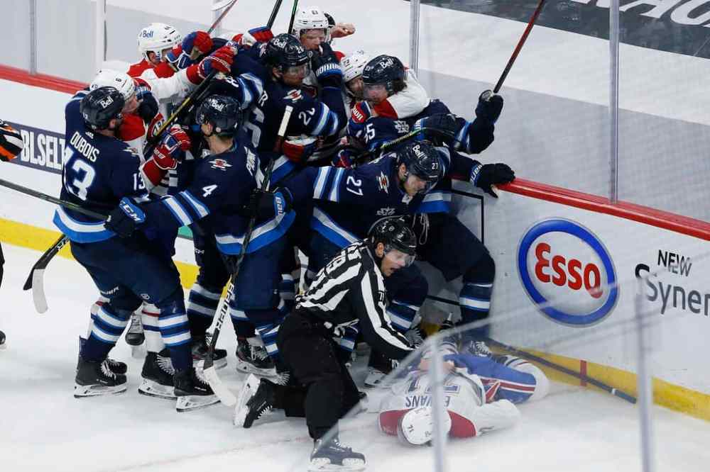 CP
A scrum ensues between Montreal Canadiens players and Winnipeg Jets players as Canadiens' player Jake Evans lies motionless on the ice after getting hit by Scheifele. THE CANADIAN PRESS/John Woods
