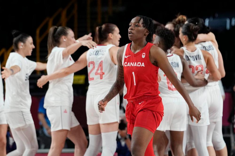 Eric Gay - AP
Canada's Shaina Pellington walks off the court as Serbia players celebrate their win in a women's basketball game at the 2020 Summer Olympics on Monday.