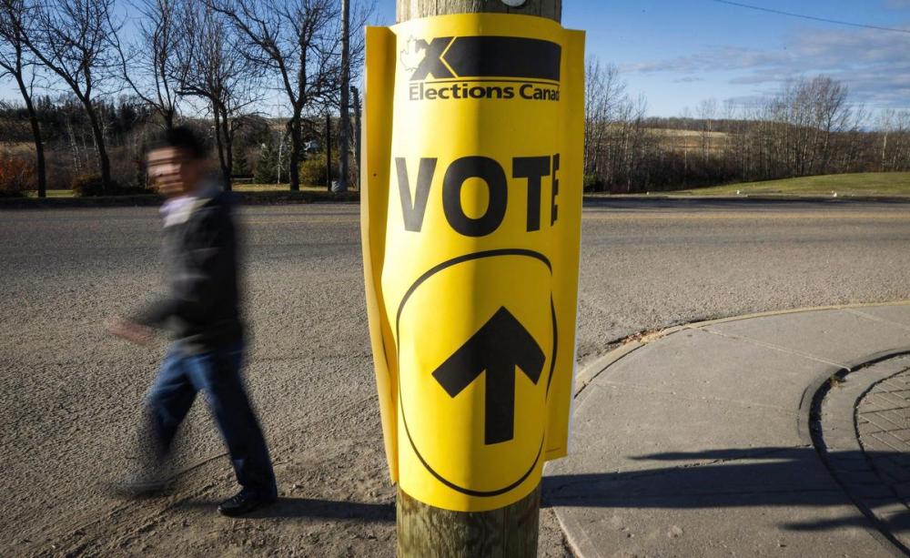 Jeff McIntosh - THE CANADIAN PRESS FILE PHOTO
A voter walks past a sign directing voters to a polling station for the Canadian federal election in Cremona, Alta. on Oct. 19, 2015.