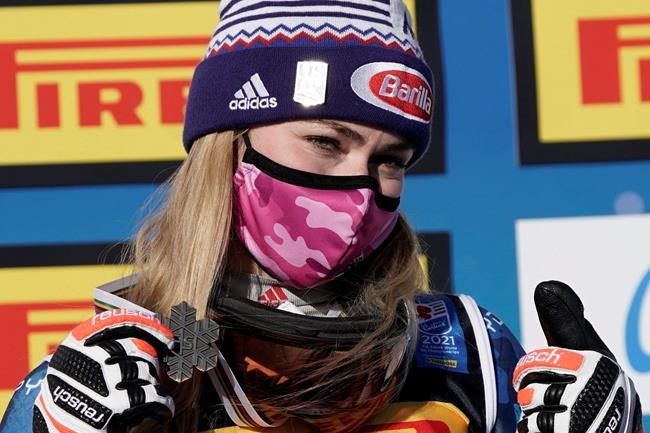 Mikaela Shiffrin, of the United States, shows her bronze medal on the podium after the women's super-G, at the alpine ski World Championships, in Cortina d'Ampezzo, Italy, Thursday, Feb. 11, 2021.(Giovanni Auletta/Pool photo via AP)