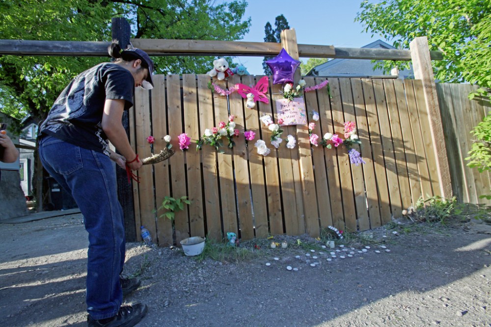 ERIK PINDERA / WINNIPEG FREE PRESS FILES
Joshua Dare, 16, holds a feather at the vigil Wednesday in the alley behind Boyd Avenue for a baby that was found dead in a garbage bin on May 3.
