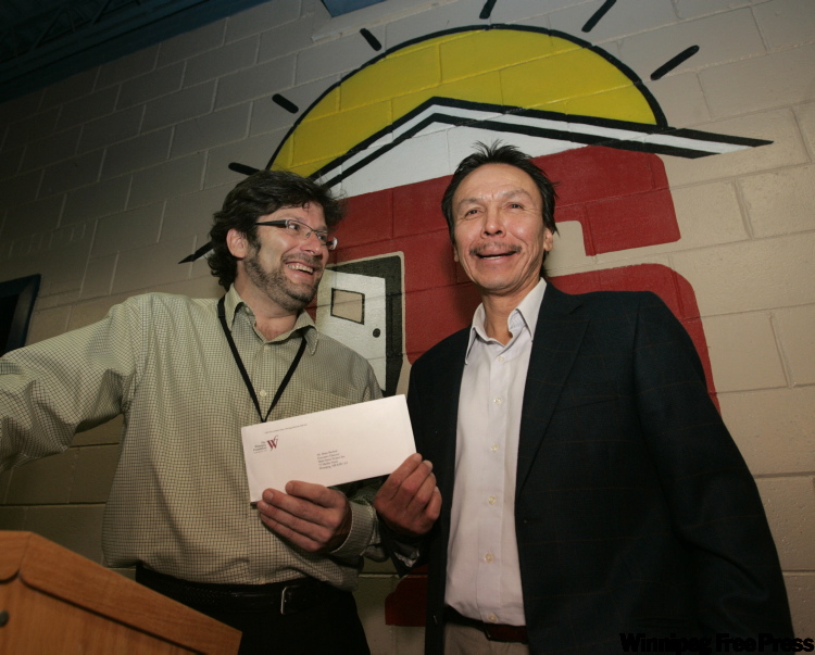 WAYNE.GLOWACKI@FREEPRESS.MB.CA
December 16, 2009: Faron Hall, right, gives a $1,000 cheque from the Faron Hall National Fund for The Homeless to Brian Bechtel, executive director of the Main Street Project. The Manitoba Life Saving Society also presented Hall with two medals for his efforts at a ceremony at the project.