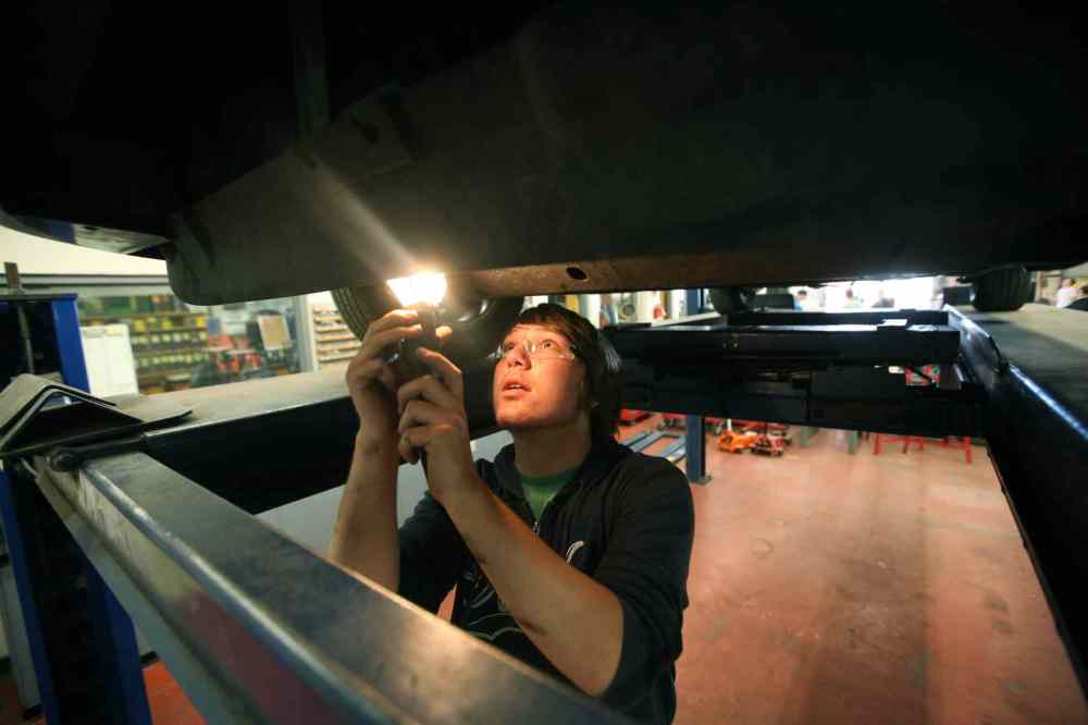 Grade 11: Garrett examines the undercarriage of a vehicle that needs repair work in his Power Mechanics class. (Ruth Bonneville / Winnipeg Free Press)