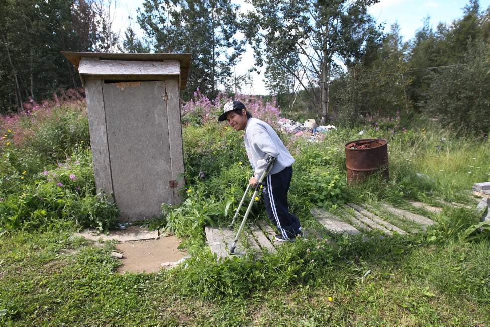 Positioning his crutches carefully on the sinking wooden palettes that make a path, Taylor inches past the home's garbage pile, where the family dumps their slop pail.
(JOE BRYKSA / WINNIPEG FREE PRESS)