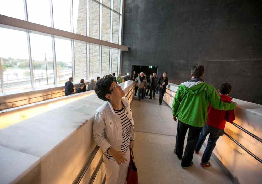 Melissa Tait / Winnipeg Free Press
Teresa Yong, who travelled from British Columbia, glances up at the dozens of alabaster ramps stacked throughout the Canadian Museum for Human Rights. Thousands had reserved tickets for the four gallery preview tour on Saturday and Sunday. That is only four of 11 galleries, the rest of which open Sept. 27.
