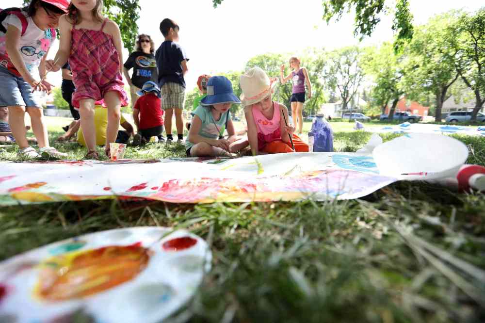 Charlie (left) and Zoe in kindergarden paint outside with classmates.