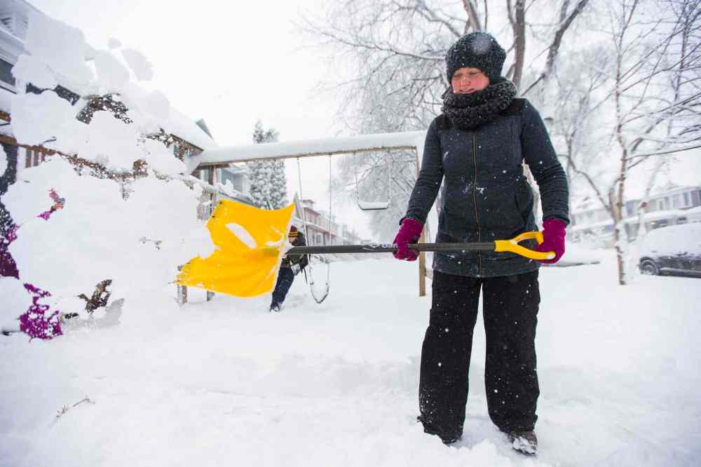 Jennifer Forster shovels snow after a big storm in Winnipeg. (Mikaela MacKenzie / Winnipeg Free Press)
