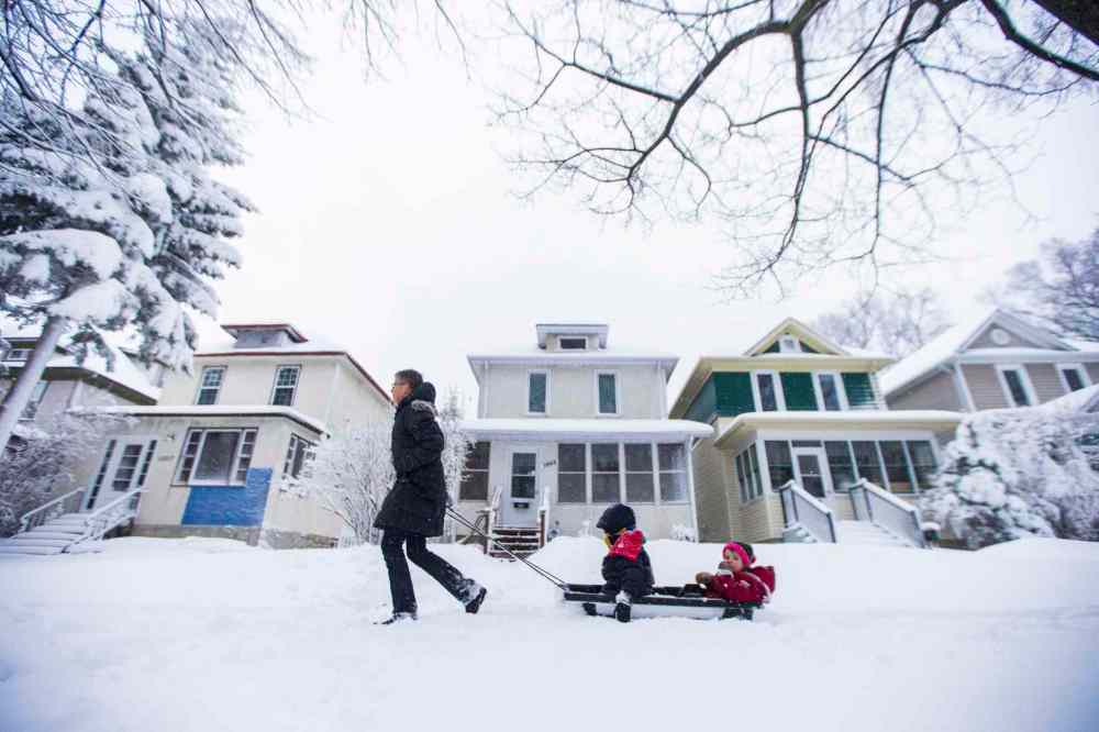 Betty Phillips pulls her grandchildren, Mac (left) and Ida May Meacham, down the sidewalk in a sled.
