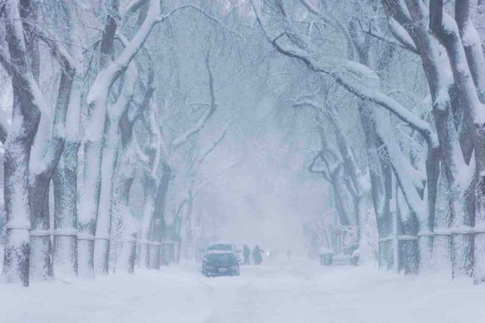People navigate the snowy conditions after a winter storm in Winnipeg. (Mikaela MacKenzie / Winnipeg Free Press)