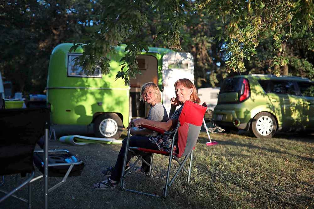 Maddox Kamphius sits with his grandma Marliss Meyer while they camp with family just west of Brandon on Tuesday evening. (Tim Smith / The Brandon Sun)