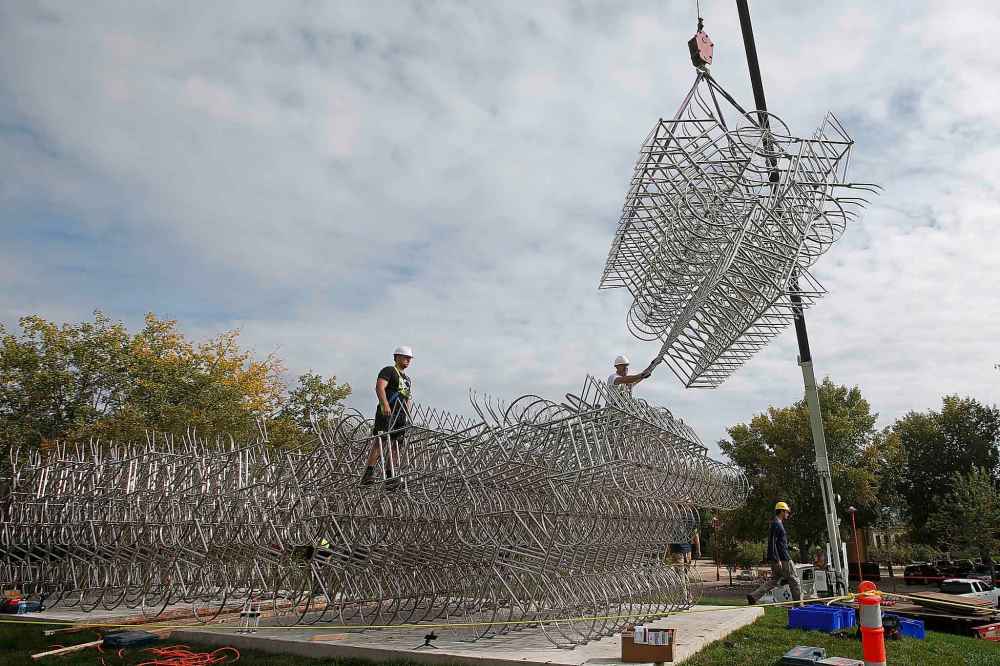 JOHN WOODS / WINNIPEG FREE PRESS
Matt Syles (left) and Dan Page, art installation technicians with MTEC, work on installing a bicycle sculpture by artist Ai Weiwei in Winnipeg Tuesday.