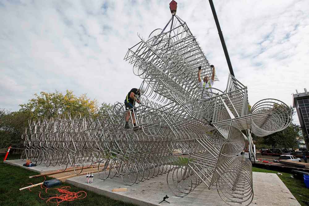 JOHN WOODS / WINNIPEG FREE PRESS
Matt Syles (left) and Dan Page, art installation technicians with MTEC, work on installing a bicycle sculpture by artist Ai Weiwei in Winnipeg Tuesday.