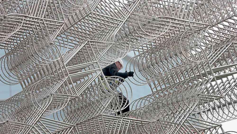 PHIL HOSSACK / WINNIPEG FREE PRESS
Forever Bicycles overseer Dan Page clambers over the sculpture Thursday.