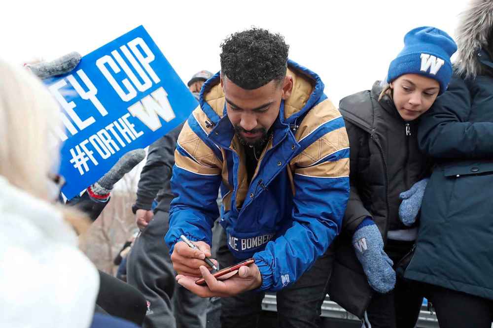 Winnipeg Blue Bomber running back Andrew Harris signs autographs during the parade. (Ruth Bonneville / Winnipeg Free Press)
