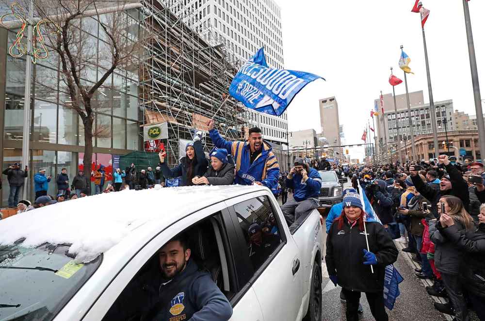 Team members wave the Bomber flag. (Ruth Bonneville / Winnipeg Free Press)