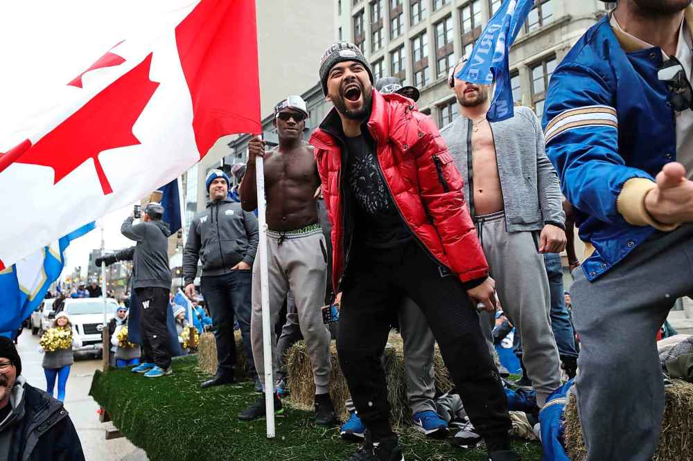 Blue Bomber Nic Demski (in red), celebrates with Jonathan Kongbo (left with flag) along with their teammates. (Ruth Bonneville / Winnipeg Free Press)
