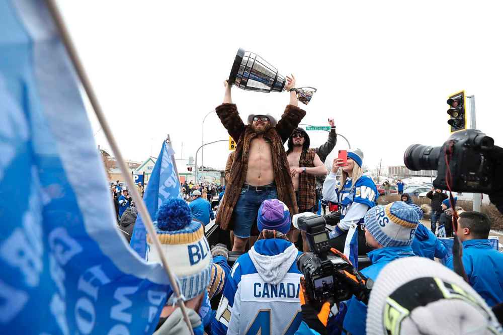 The cup is hoised in the air. (Ruth Bonneville / Winnipeg Free Press)