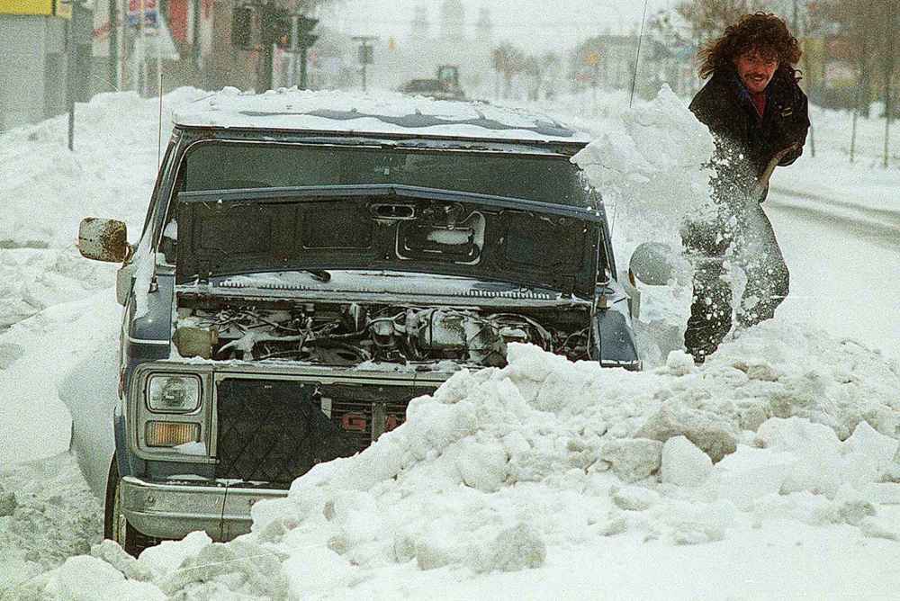 Neil Mathews digs out his van on Main Street. He figured it would take the better part of the day to shovel out the vehicle and get it running. (Joe Bryksa-Winnipeg Free Press files)