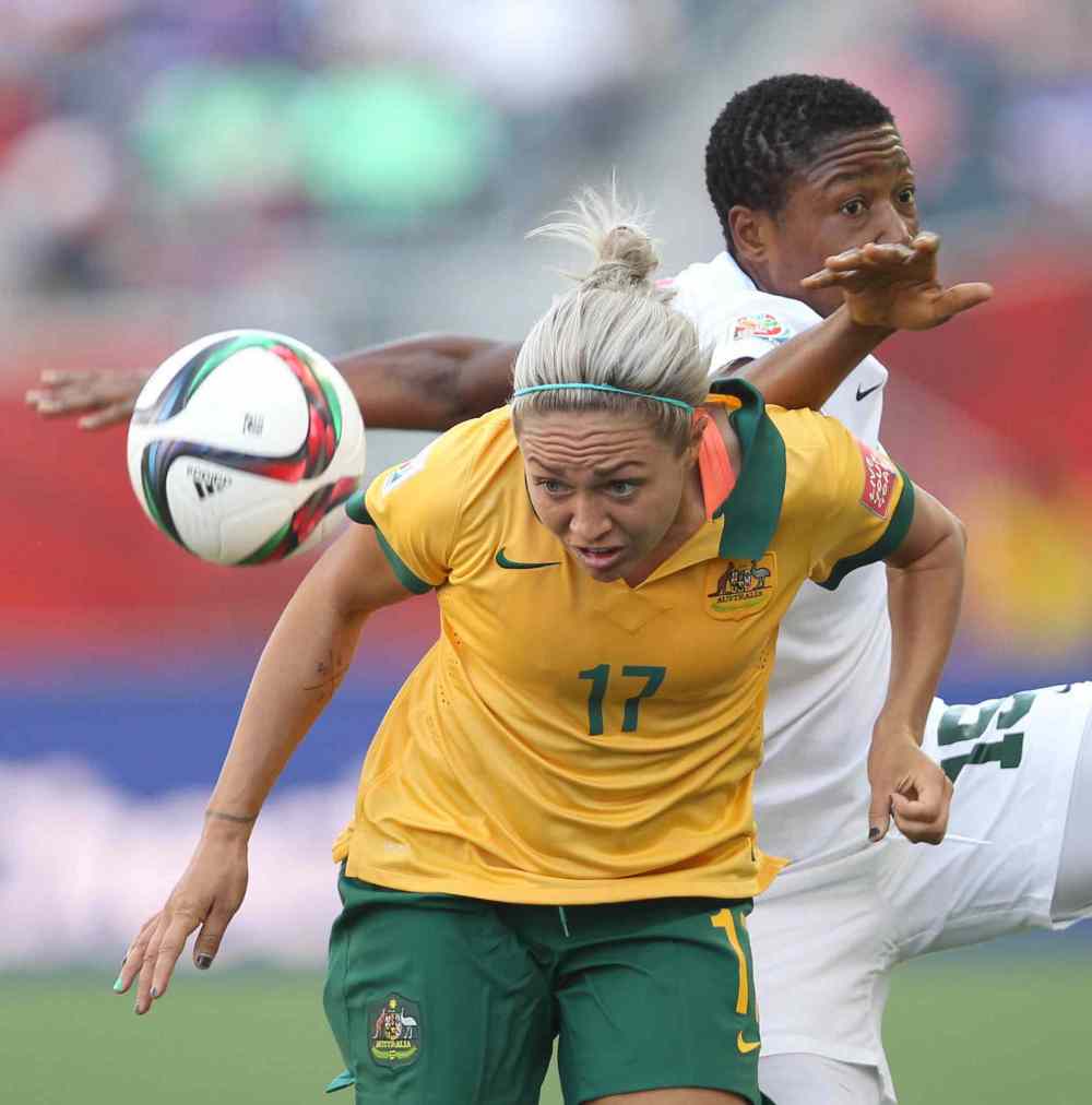 Australia's Kyah Simon, front, and Nigeria's Ugo Njoku fight for the ball during second-half FIFA Women's World Cup action at Investors Group Field. June 12, 2015 (JOE BRYKSA / WINNIPEG FREE PRESS)