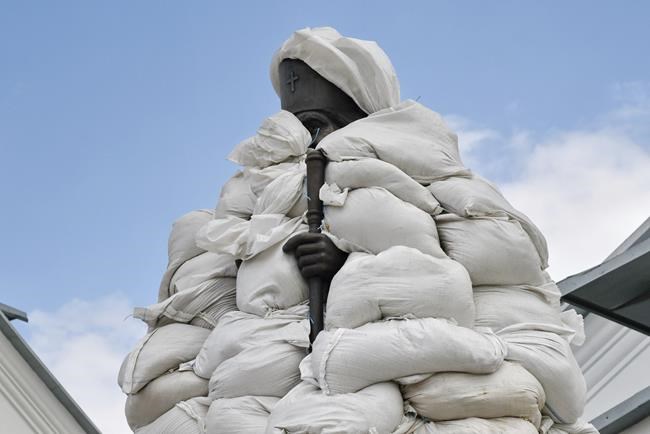 The monument of St. John of Shanghai is covered with sandbags in a yard the Orthodox Skete in honour of St. John of Shanghai in Adamivka, near Slovyansk, Donetsk region, Ukraine, Tuesday, May 10, 2022. (AP Photo/Andriy Andriyenko)