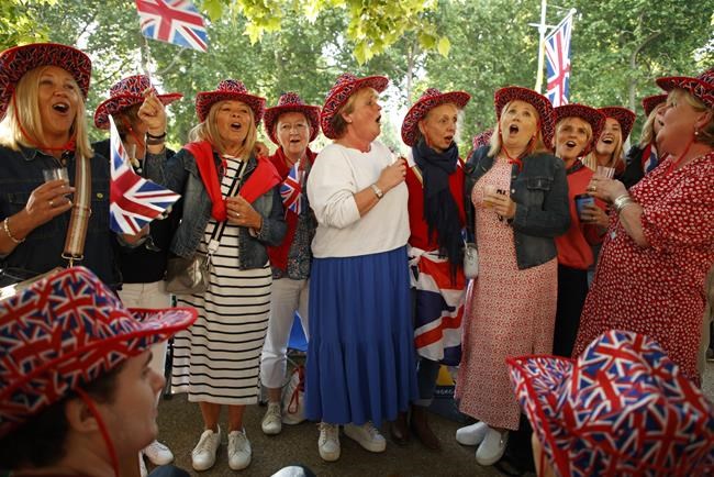 Royal fans sing the national anthem as they gather along the Mall leading to Buckingham Palace in London, Thursday June 2, 2022, on the first of four days of celebrations to mark the Platinum Jubilee. The events over a long holiday weekend in the U.K. are meant to celebrate the monarch's 70 years of service. (AP Photo/David Cliff)