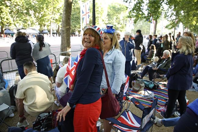 Royal fans gather along the Mall leading to Buckingham Palace in London, Thursday June 2, 2022, on the first of four days of celebrations to mark the Platinum Jubilee. The events over a long holiday weekend in the U.K. are meant to celebrate the monarch's 70 years of service. (AP Photo/David Cliff)