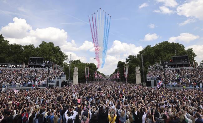 The red arrows fly over the crowd as they wait for the royal family to appear on the balcony of Buckingham Palace in London, Thursday June 2, 2022, on the first of four days of celebrations to mark the Platinum Jubilee. The events over a long holiday weekend in the U.K. are meant to celebrate the monarch’s 70 years of service. (Richard Pohle, Pool Photo via AP)