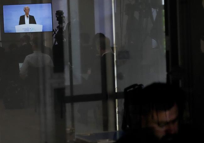 Christine Lagarde, European Central Bank President is seen on a screen reflected in a translator's booth as she explains the Governing Council's monetary policy decisions during a press conference in Amsterdam, Netherlands, Thursday, June 9, 2022. The European Central Bank said it would carry out its first interest rate increase in 11 years in July, followed by another hike in September. The bank made the surprise move Thursday, saying that inflation had become a