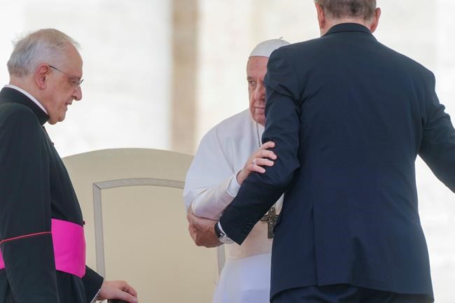 FILE - Pope Francis is helped standing at the end of his weekly general audience in St. Peter's Square at The Vatican, Wednesday, June 1, 2022. Pope Francis canceled a planned July trip to Africa on doctors' orders because of ongoing knee problems, the Vatican said Friday, June 10, 2022, raising further questions about the health and mobility problems of the 85-year-old pontiff. (AP Photo/Gregorio Borgia)