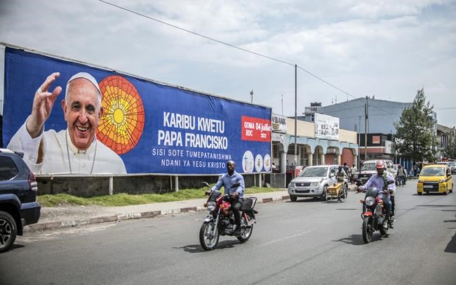 People drive past a banner welcoming Pope Francis to Goma, Democratic Republic of Congo, Friday June 10, 2022. Pope Francis canceled a planned July trip to Africa on doctors' orders because of ongoing knee problems, the Vatican said, raising further questions about the health and mobility problems of the 85-year-old pontiff. (AP Photo/Moses Sawasawa)