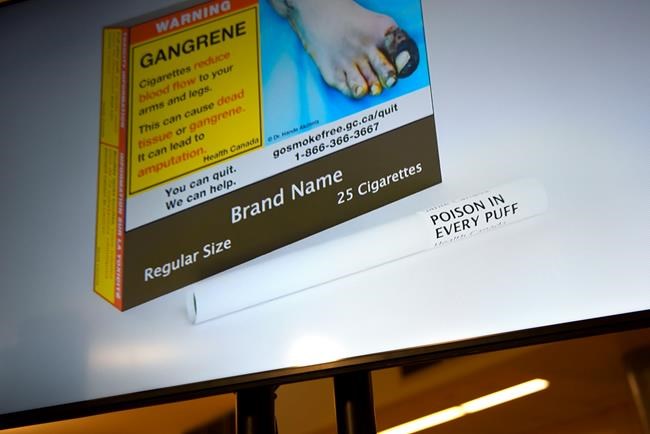 An example of cigarette packaging with expanded warnings, including a warning printed on the cigarettes themselves, is shown on a screen after a news conference on expanded regulations for tobacco products, in Ottawa, on Friday, June 10, 2022. THE CANADIAN PRESS/Justin Tang