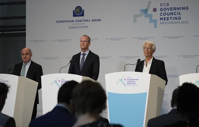Christine Lagarde, European Central Bank President, behind blue lectern, Vice-President Luis de Guindos, left, and Netherlands Bank (DNB) President Klaas Knot, second left, explain the Governing Council's monetary policy decisions during a press conference in Amsterdam, Netherlands, Thursday, June 9, 2022. The European Central Bank said it would carry out its first interest rate increase in 11 years in July, followed by another hike in September. The bank made the surprise move Thursday, saying that inflation had become a
