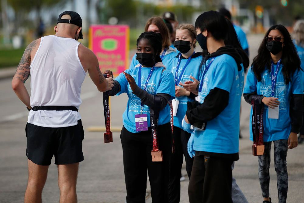 JOHN WOODS / WINNIPEG FREE PRESS
Volunteers hand out participation medals at the Manitoba Marathon at the University of Manitoba.